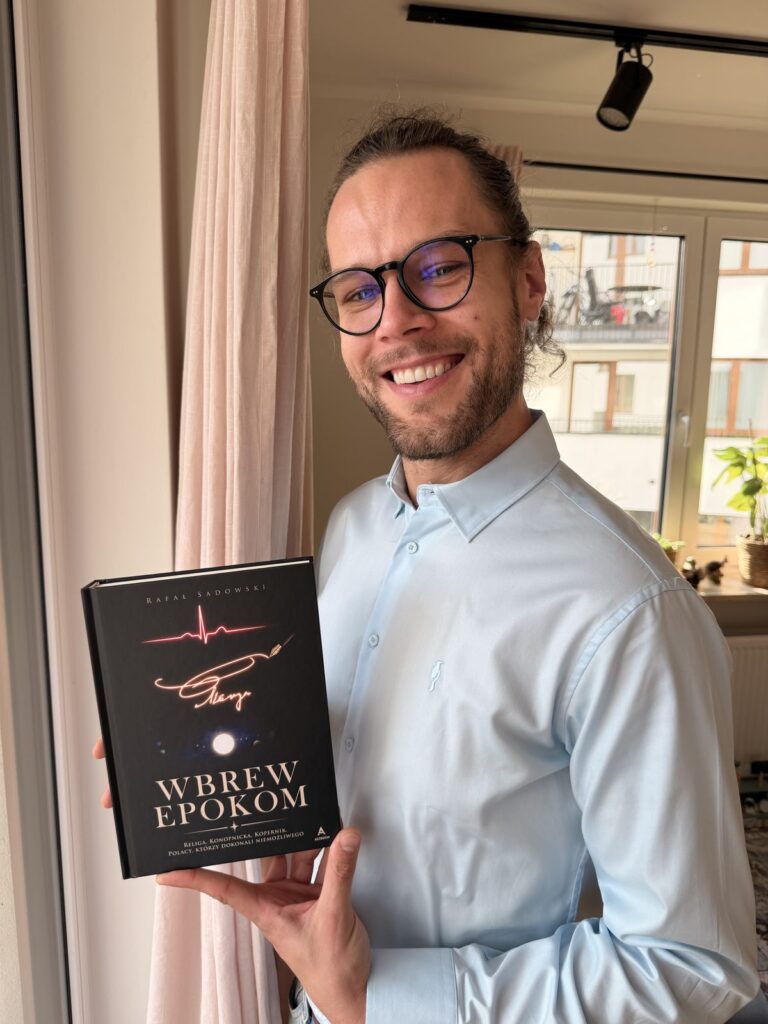 Rafał Sadowski z egzemplarzem książki Wbrew epokom